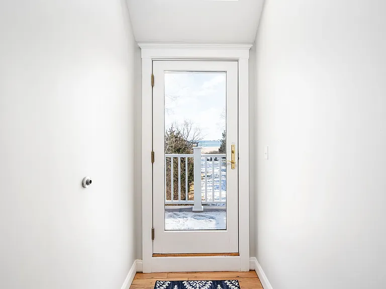 Upstairs door to outdoor ocean-facing balcony and seating for two.