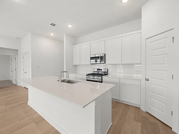 Kitchen in the Brazos home plan by Trophy Signature Homes - REPRESENTATIVE PHOTO