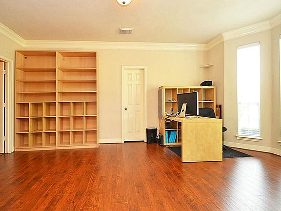 Large hard wood floor room with bay windows.