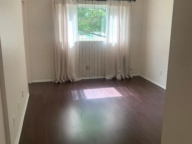 Large Master bedroom with view of trees in the park like area behind the building.