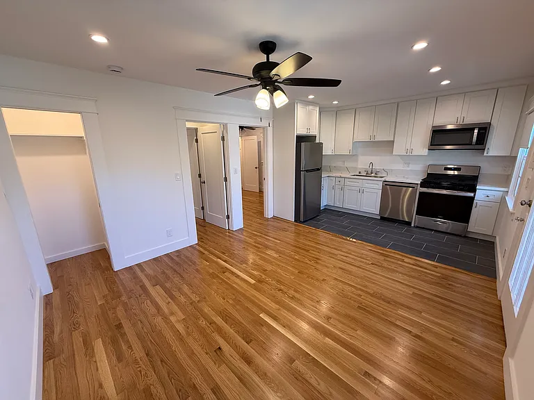 VIEW OF ENTIRE FRONT LIVING AREA AND KITCHEN WITH ACCESS TO STORAGE CLOSET AND BOTH BEDROOMS