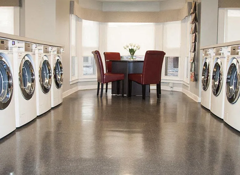 Communal laundry room with seating.