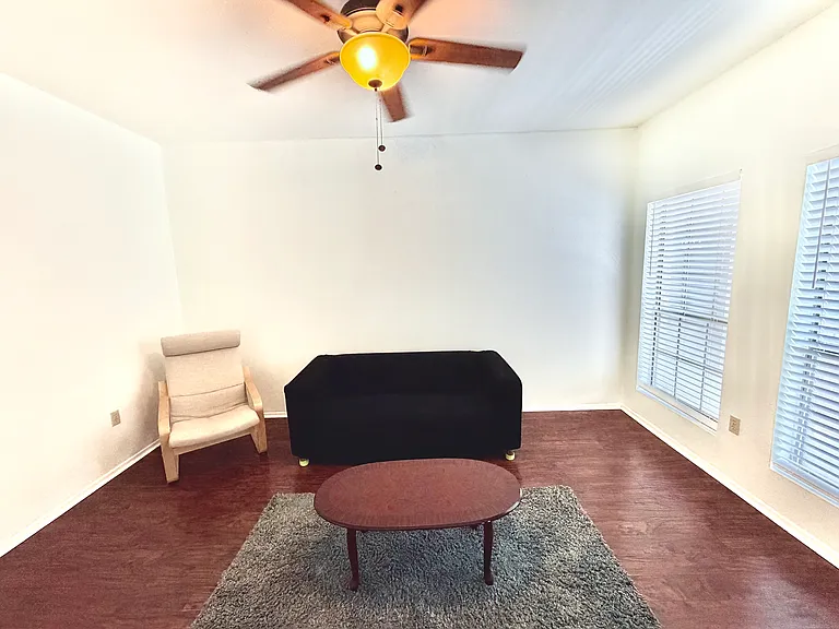 Well lighted living room complimentary with a sofa, IKEA chair, and a coffee table