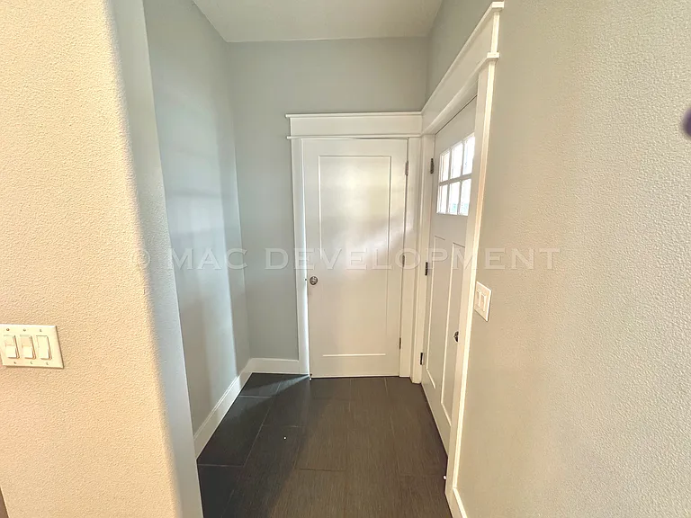 Entrance from Back Door into Drop Zone and Bathroom to the Right.
