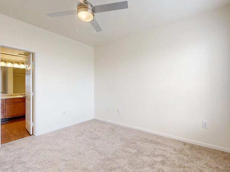 Spacious apartment bedroom with carpet floor.