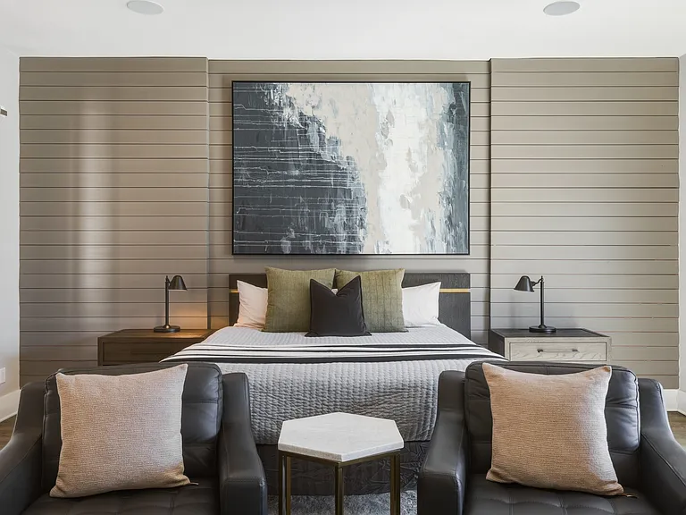 Spacious primary suite featuring a plush king bed, cozy seating area, walk-in closet with custom built-ins, spa-like bath, smart TV and private access to an 11x9 deck. Your private retreat to unwind in comfort.