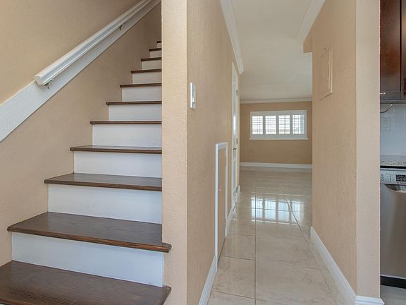Kitchen, Living Room (Downstairs), and Hardwood Staircase Leading To Upstairs Bedrooms