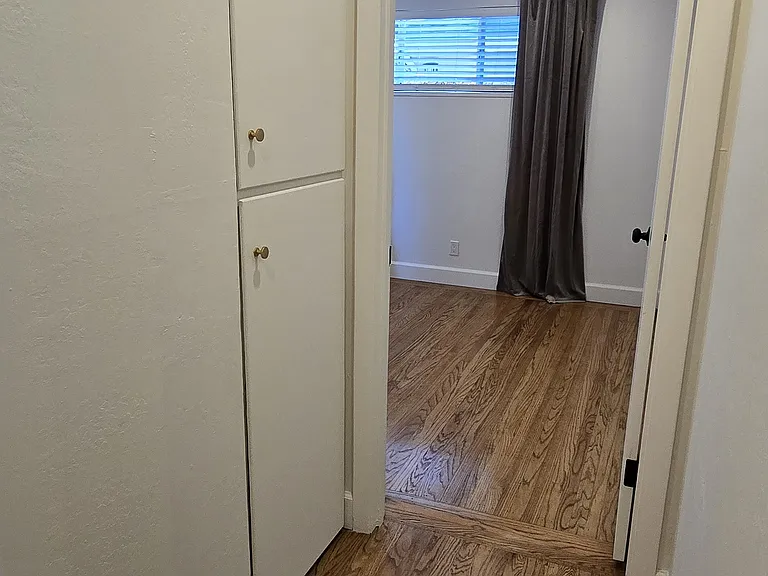 Hallway to master bedroom with linen closet storage.