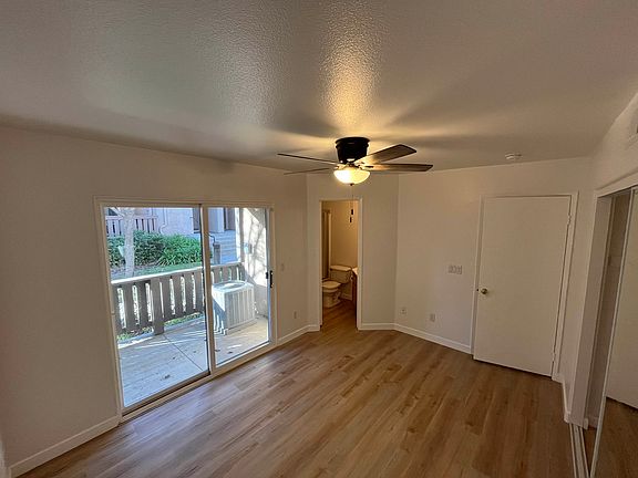 Primary bedroom with en suite, spacious closet, and sliding glass door to first floor patio