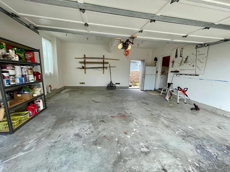 2-car garage with pegboard and surf rack.