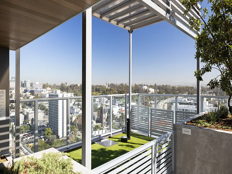 Luxurious rooftop terrace with lush green landscaping, offering panoramic city views and stylish modern design.