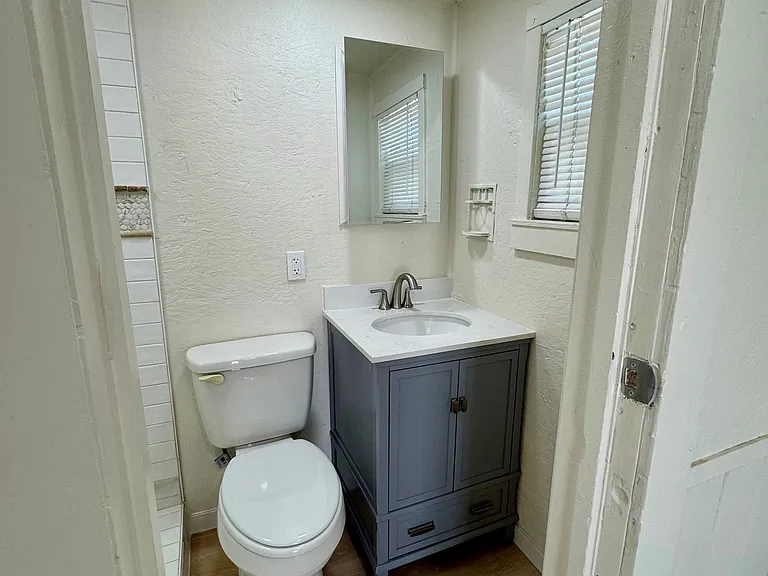 Updated bathroom with new vanity, medicine cabinet, window, and toilet.