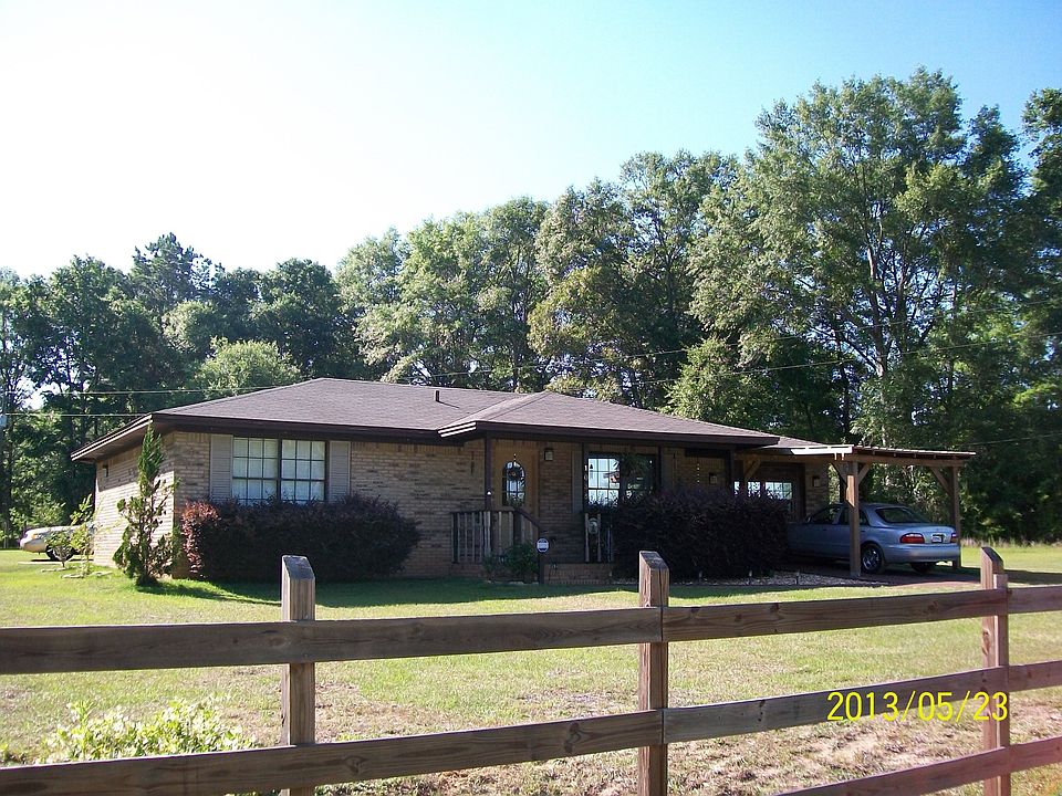 brick home on paved road 