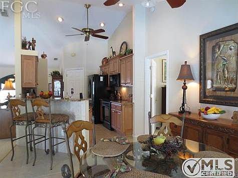 Kitchen with breakfast bar and dinette area has window overlooking pool area and a door to the lanai.