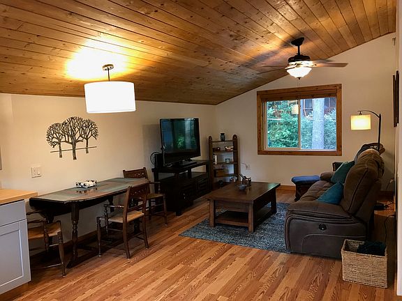 Living room with reclining sofa, TV & DVD player and overhead ceiling fan.