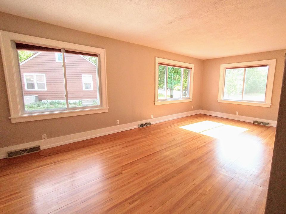 Large main floor living room, with original hardwood floors and lots of natural light.