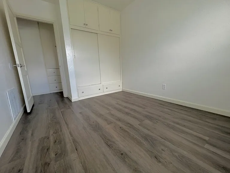 Bedroom with Built-In Cabinets and Closet - Large Window on Opposite Wall. Not shown in photo
