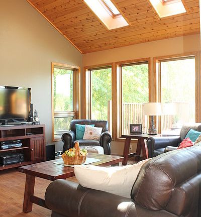 Bright and comfortable living room
						:
						Vaulted ceilings, skylights, huge windows, and a fireplace in living room.