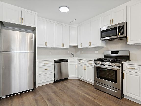 Stainless steel appliances. White cabinetry.