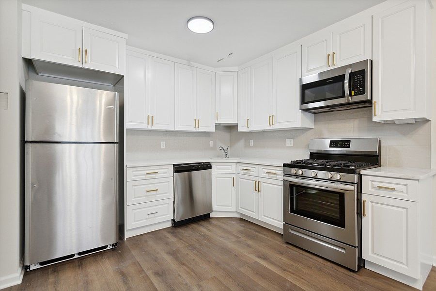 Stainless steel appliances. White cabinetry.