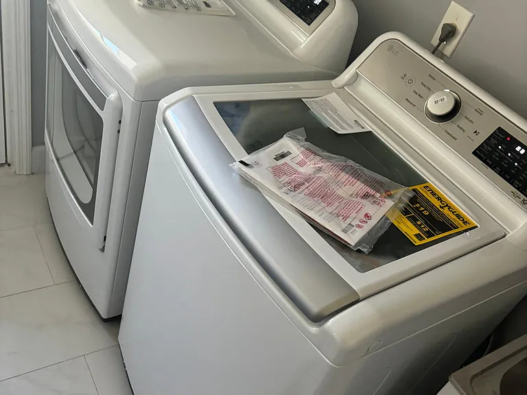 Washer Dryer in full laundry room with separate utility sink.