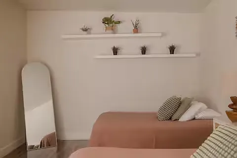 Spacious bedroom with two full beds, soft neutral bedding, and plenty of natural light. Clean and airy, it's a comfortable, functional space for a restful stay.
