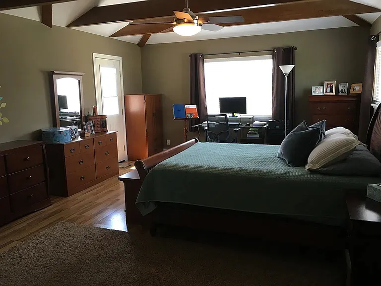 Stylish vaulted wood-beam ceiling accents the modern beauty of the bedroom. A very good sized one!