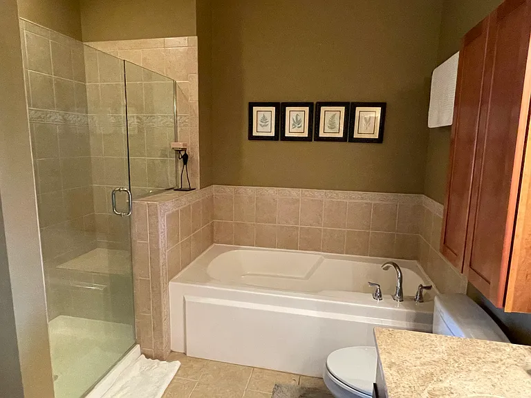 Primary bedroom ensuite bathroom with large tub and walk in shower