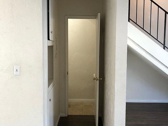 hallway to 1/2 bath with storage cabinets