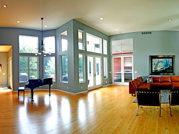 Stunning view of the foyer and living room. This exceptional living room has 15' high ceilings, maple wood floors and large windows to enjoy natural light.