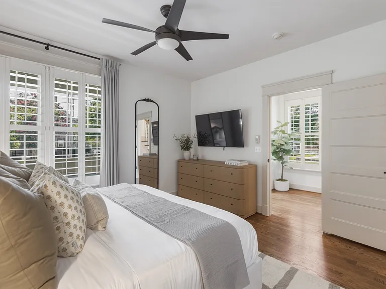 King sized bed in bedroom 2, featuring a walk-in closet, dresser, smart TV, full-length mirror, and ensuite bathroom.