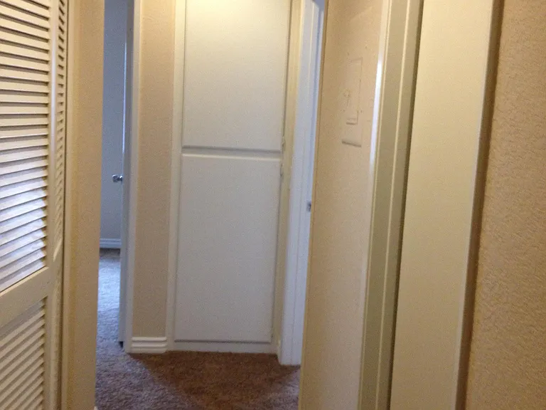 Hallway/linen closet and washer and dryer on left side of hallway.