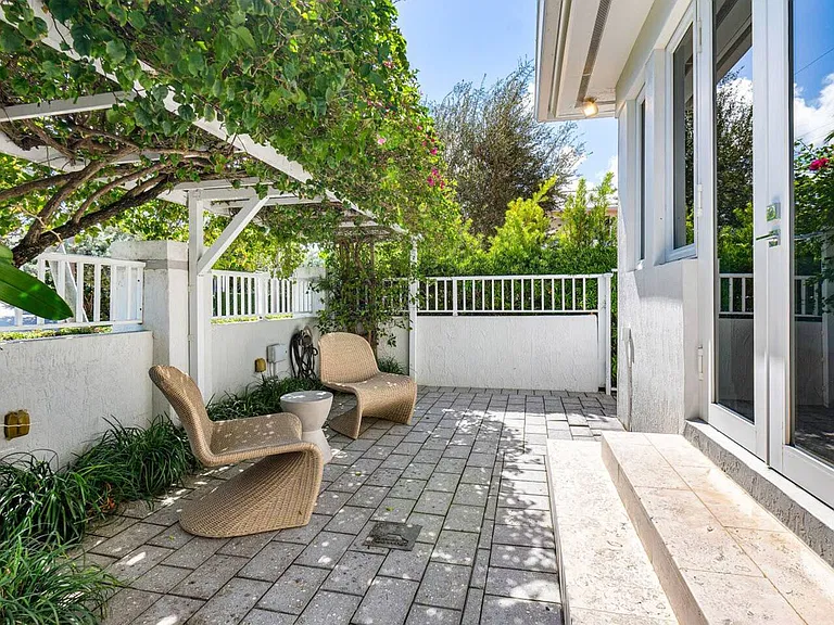 Enjoy quiet moments on the private patio, surrounded by lush greenery and comfortable seating.