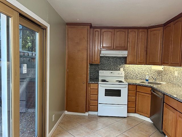 Remodeled kitchen with FULL slabs kitchen counter top and backslash, dishwasher, double pane sliding room leads to backyard