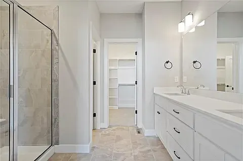 Primary bathroom leading into large walk-in closet
