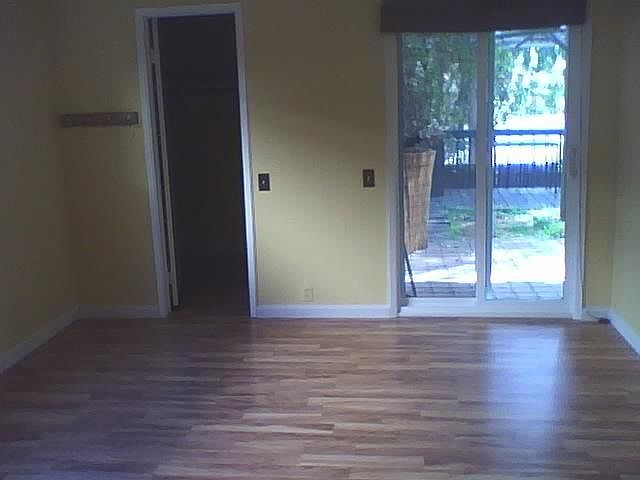 This is the primary bedroom facing east. There is a window on the north wall. Left door is walk-in closet, slider is to patio/deck area.