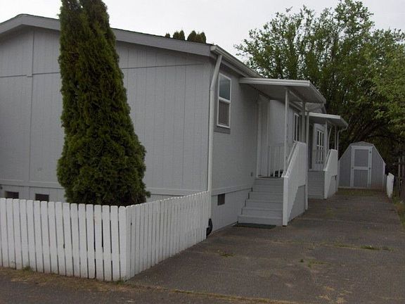 View of back entry with storage in ancillary building at rear. Tandem parking for three cars