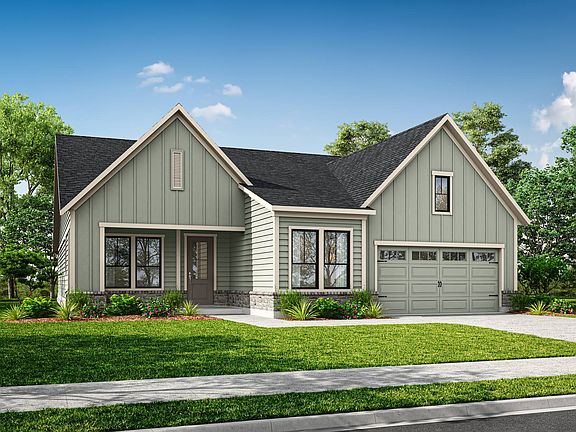 A two-story house with a gabled roof, siding in a light green color, and a garage door sits on a gra