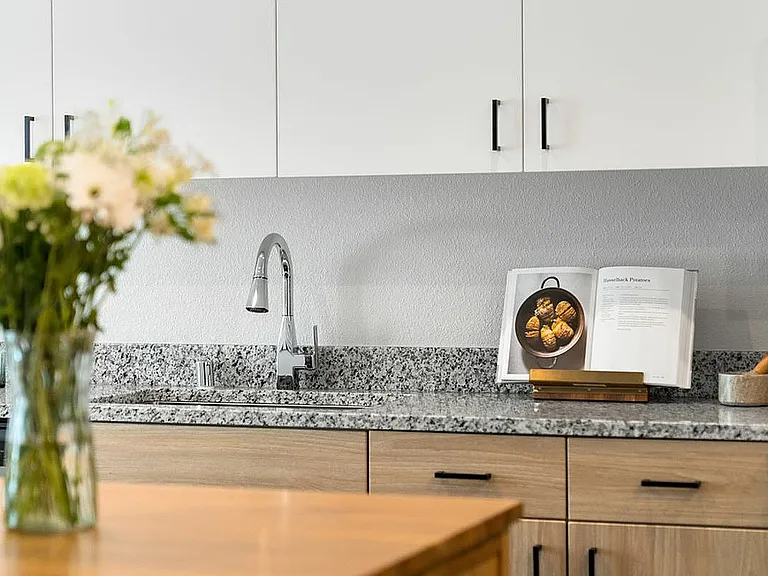 Experience sophistication in your kitchen with stylish granite and contemporary cabinetry.