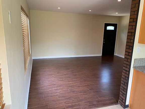 Entry door & living room: Newer wood-laminate flooring, recessed lights