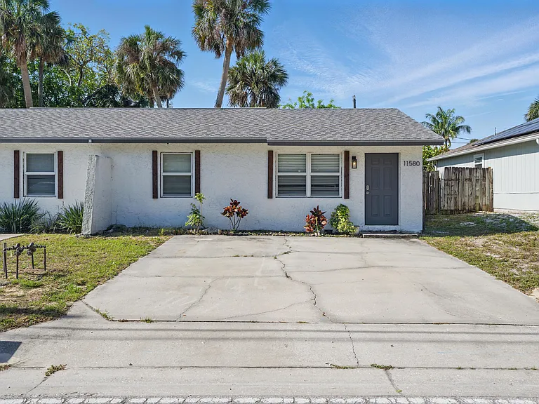 The front of the house features a clean, well-maintained exterior with a private driveway, lush greenery. Including lots of parking space for 4-5 cars