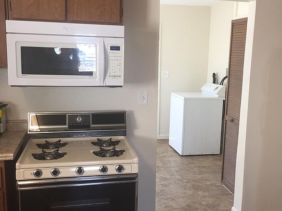 View from kitchen towards laundry room and back door. Existing refrigerator, washer and gas dryer available as-is in working condition.
