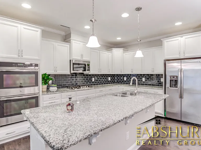 Luxurious open concept kitchen w/ oversized island, granite countertops, SS appliances, 2 wall ovens