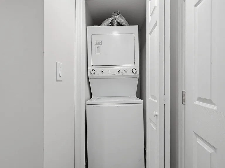 Convenient in-home laundry closet with a stacked washer and dryer for easy, everyday use.
