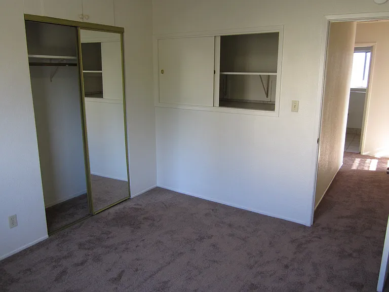 Third Bedroom with mirrored sliding doors and storage cubby with sliding doors