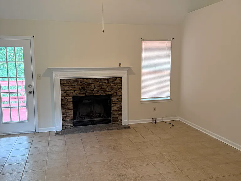 Vaulted living room with fireplace and access to back deck