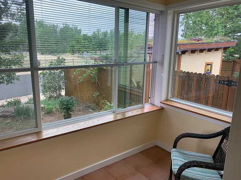 Sunroom with view to open space to the south and chicken coop in the back yard