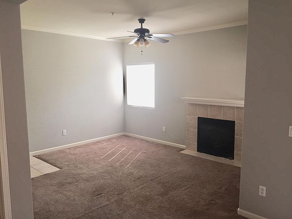 Living Room with Fan and Gas Fireplace. Entry Door to the left.