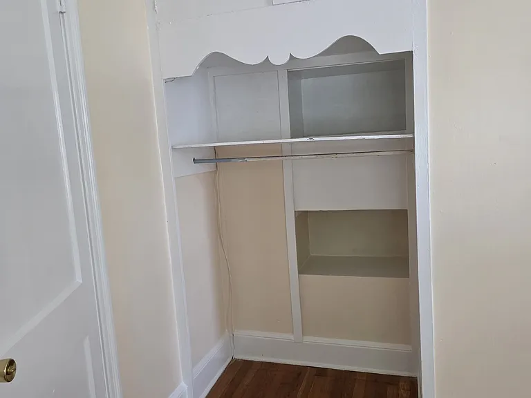 Bedroom 2 closet with closet bar, shelves and cabinet.
