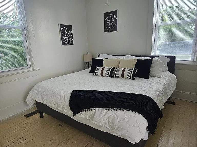 Bedroom with queen bed and 2 windows with great light